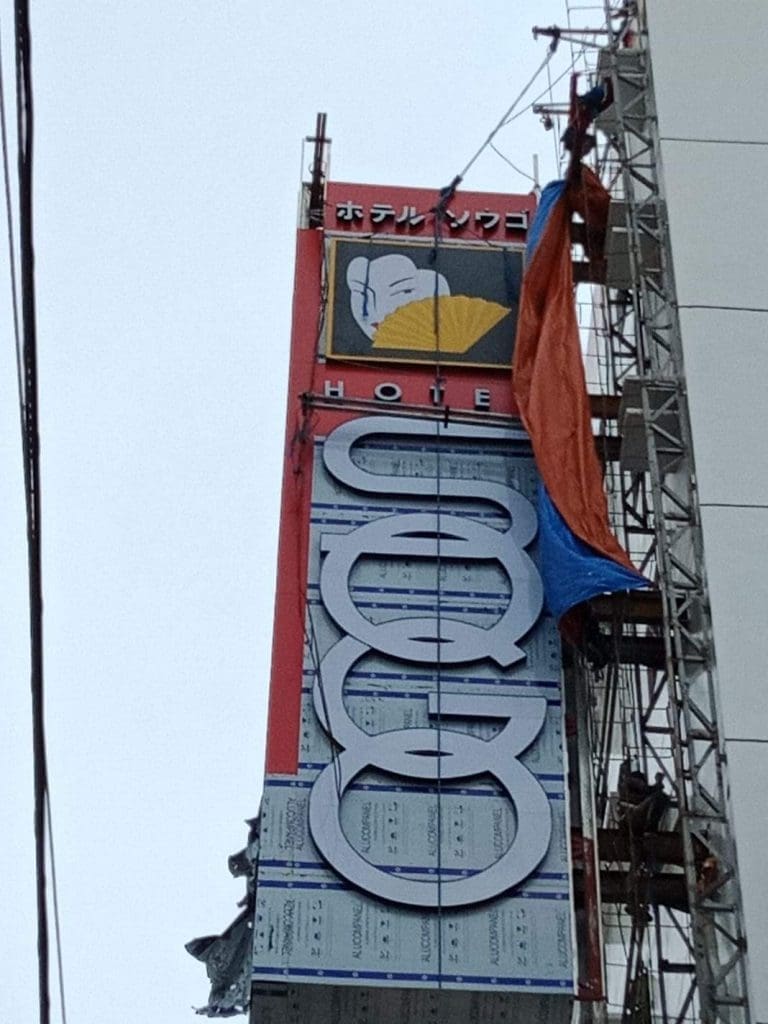 Hotel building signage installation with Japanese and English text in Quezon City, shell and fan illustration by M&G Global Ads.