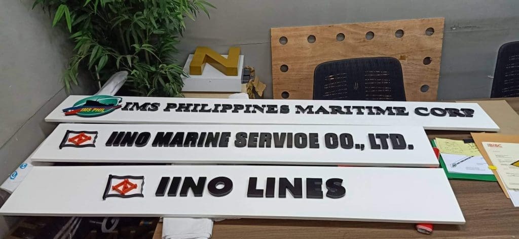 Acrylic office signboards for marine service companies in Makati, on display table with logos, by M&G Global Ads.