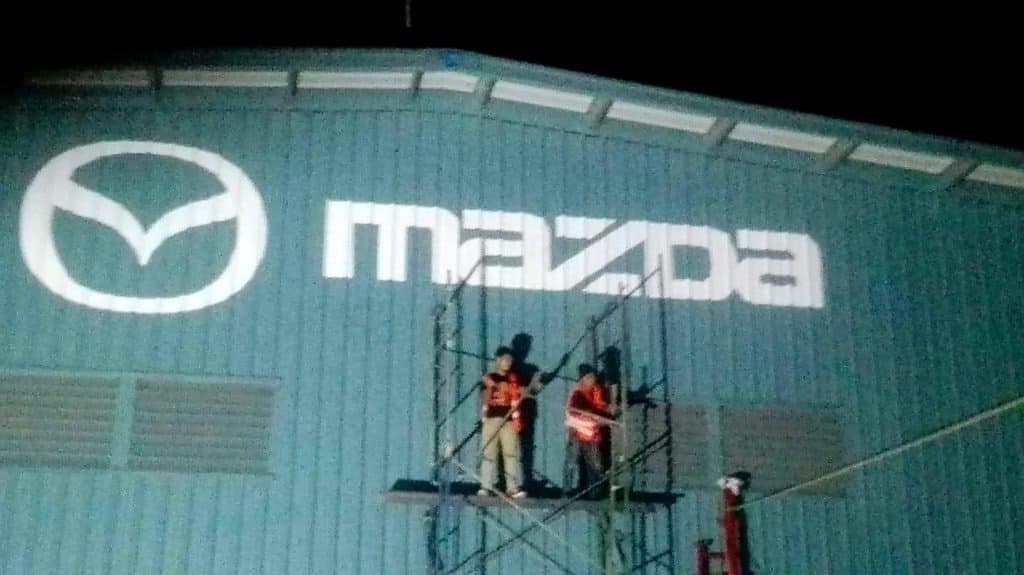 Mazda LED signage installation in Quezon City at night, with workers on scaffolding, by M&G Global Ads.