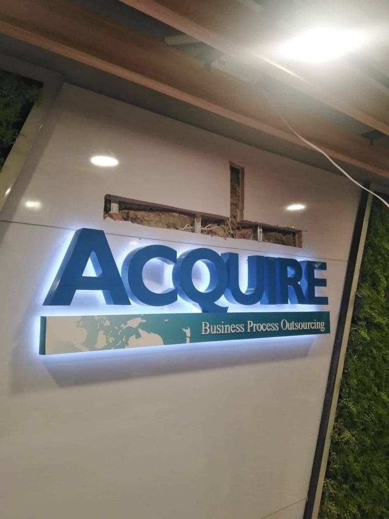 Metallic indoor signage for ACQUIRE BPO in blue LED, Quezon City office interior wall, world map detail by M&G Global Ads.