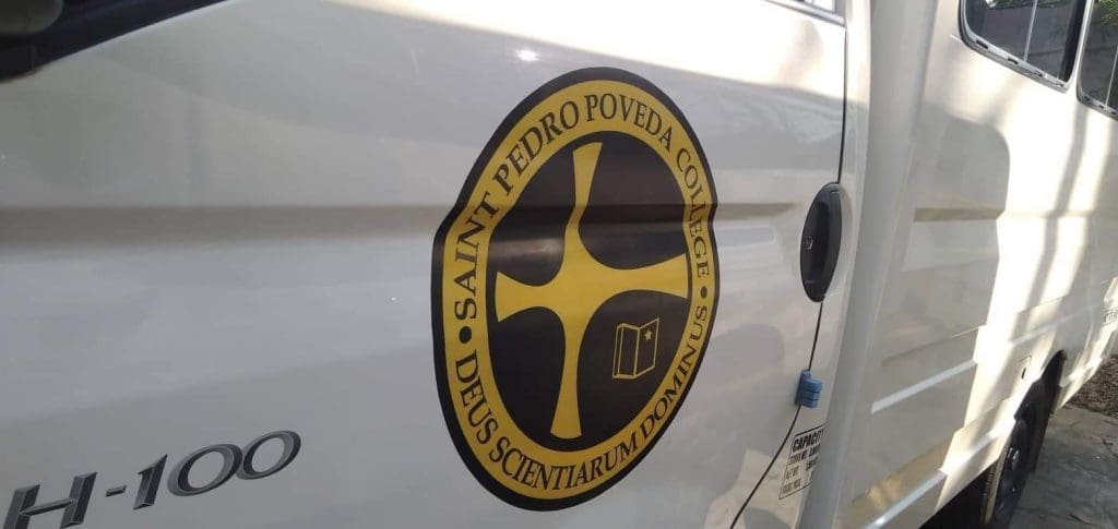 Saint Pedro Poveda College logo vehicle wrap and Latin building signage in Ortigas, Metro Manila by M&G Global Ads.
