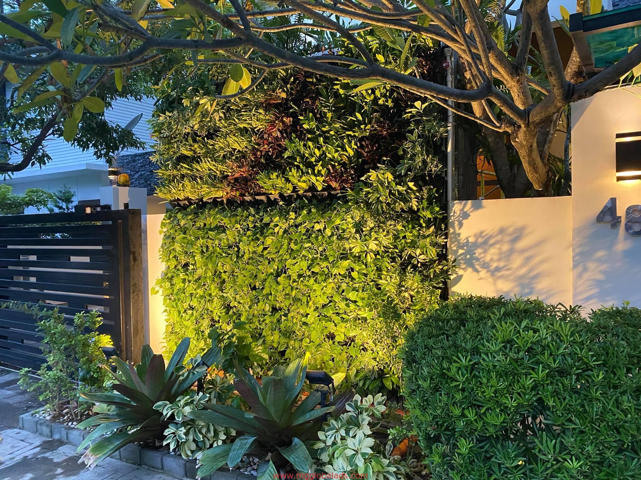 vertical garden installation in Makati with plants and trees at dusk by M&G Global Ads.