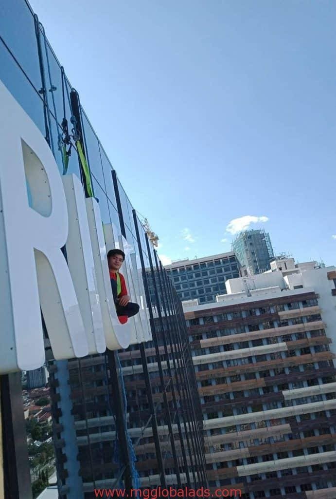 installing one trium | building sign | signages