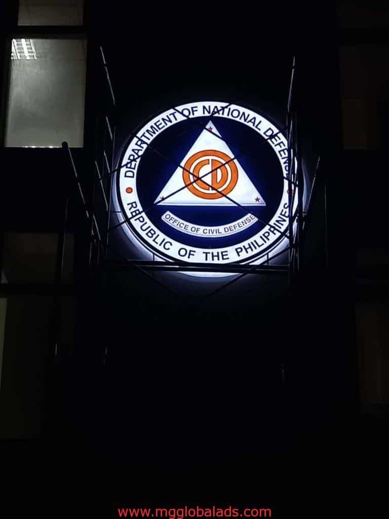 Illuminated acrylic signage for Department of National Defense in Quezon City at night by M&G Global Ads.