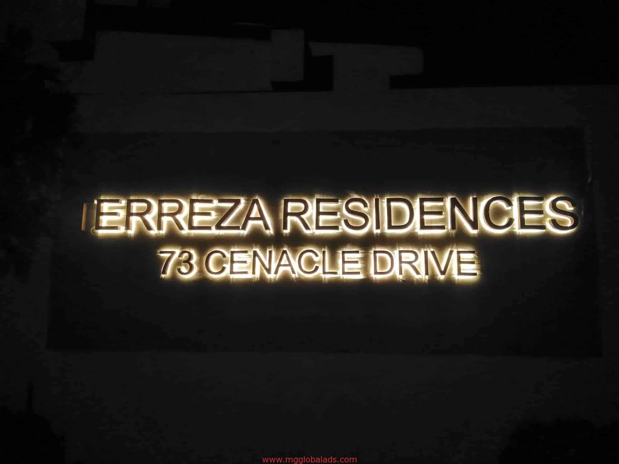 Illuminated brass building signage for ERREZA RESIDENCES in San Juan at night, glowing letters by M&G Global Ads.