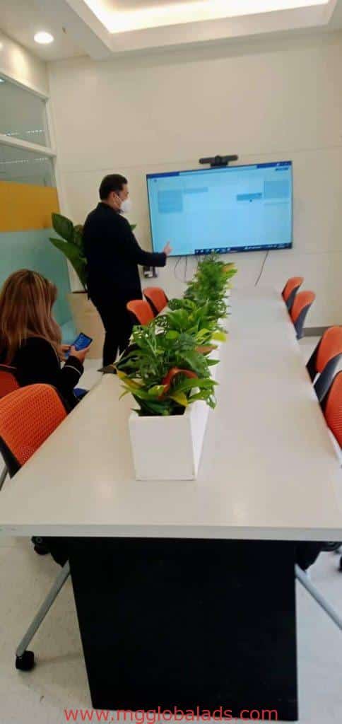 Indoor office signage at corporate client conference room in Makati, with large screen and orange chairs by M&G Global Ads.