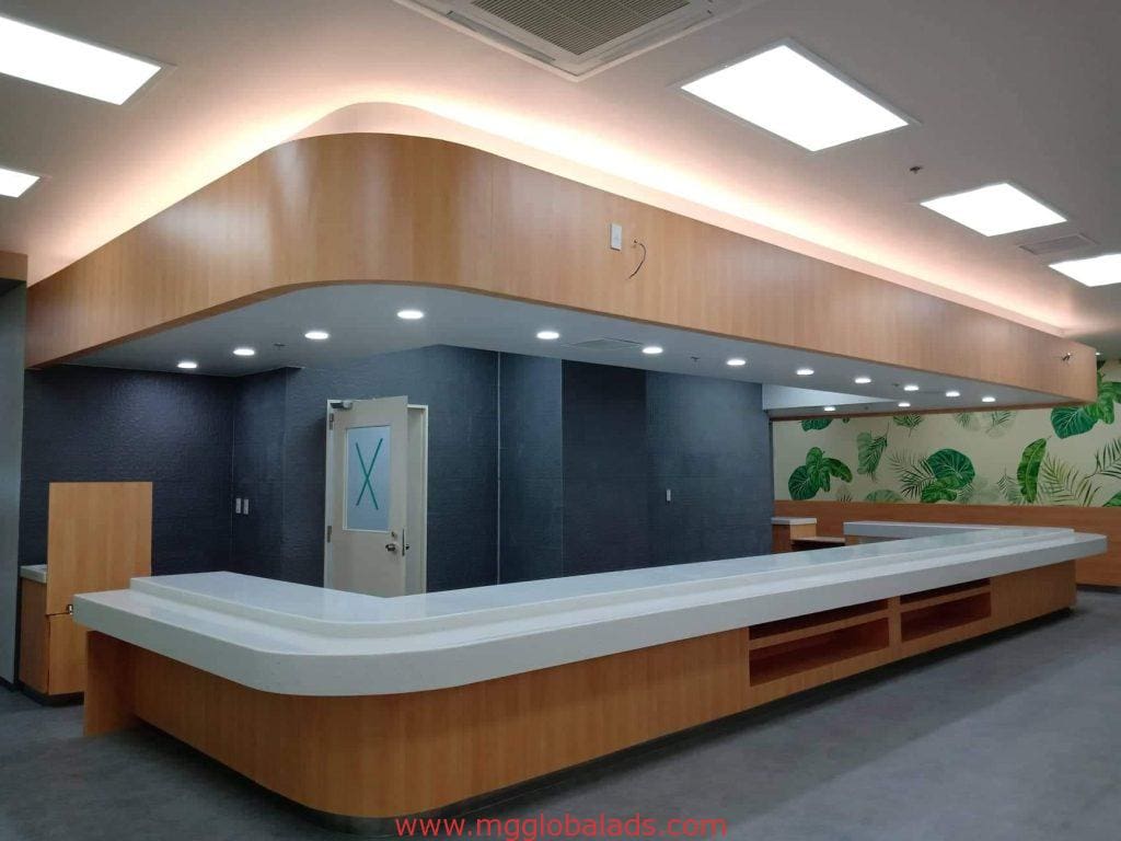 Reception desk with wood paneling, white countertop, acrylic signage in Makati office interior by M&G Global Ads.