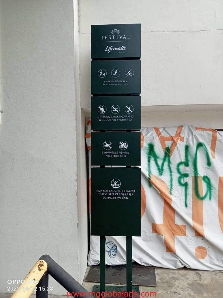 Festival Lifemalls building signage post in Makati listing rules and warnings, with a white wall behind, by M&G Global Ads.