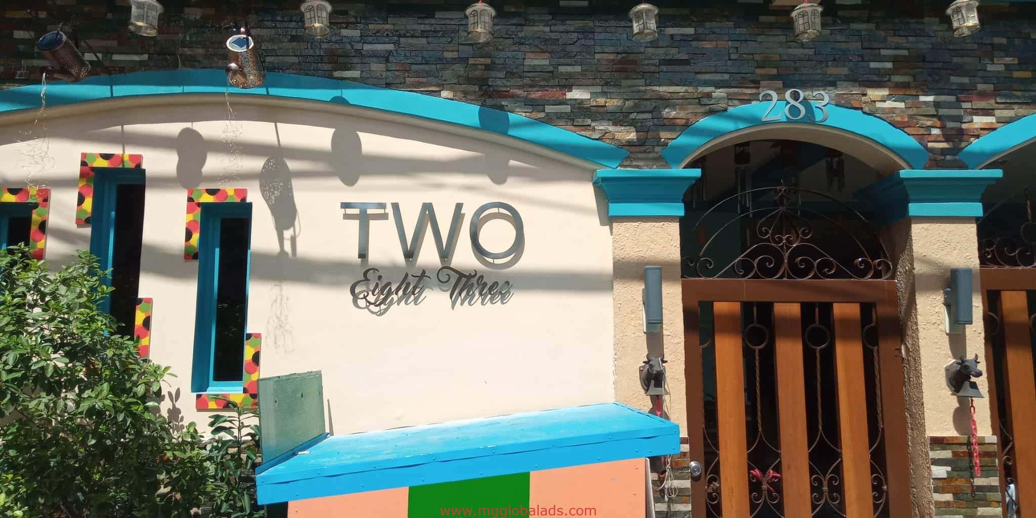 Acrylic signage for TWO Eight Three above blue and yellow facade with lantern shadows in Makati by M&G Global Ads.
