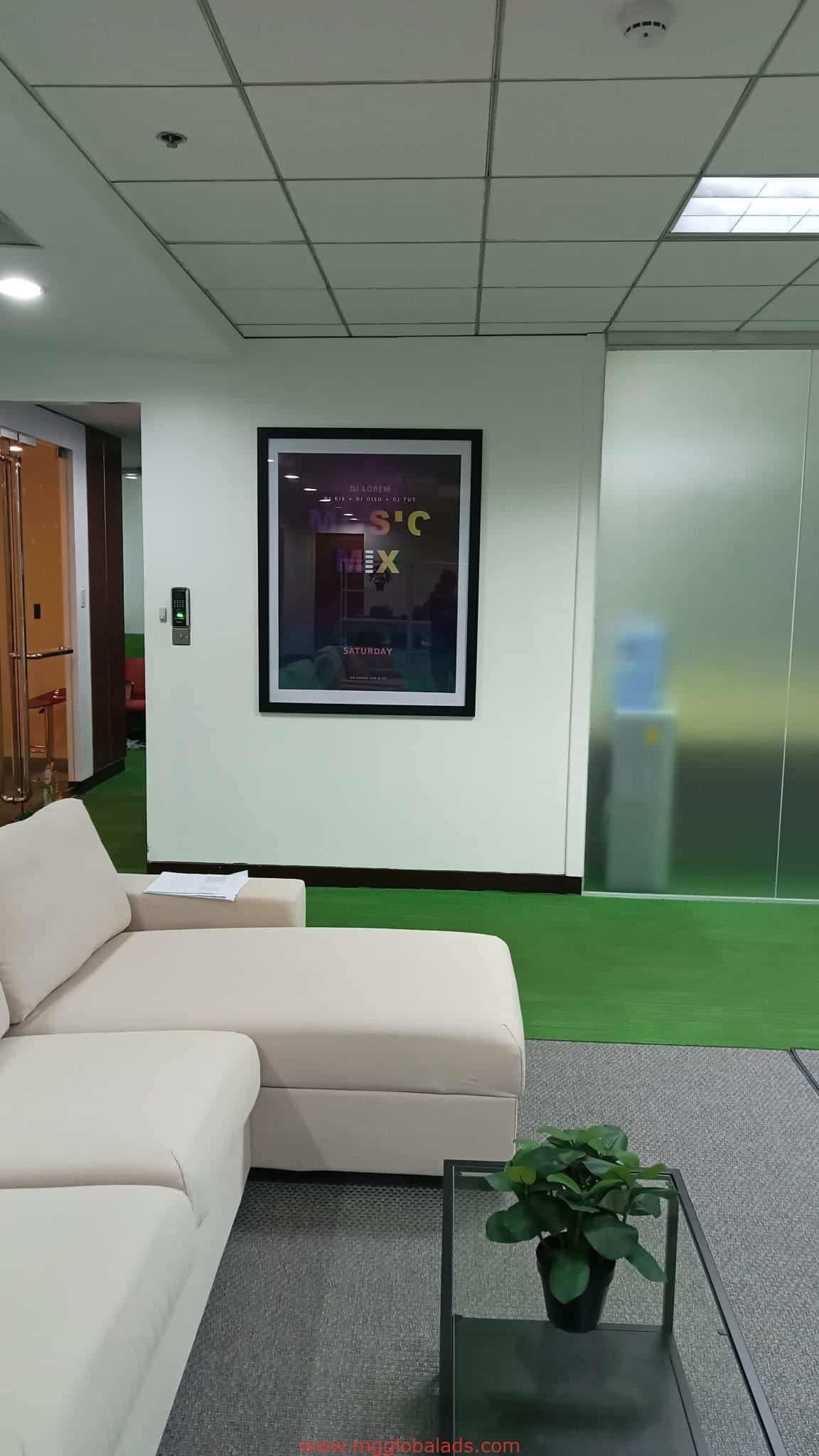 Sleek metallic office signage for client in BGC, modern lounge sofa, glass coffee table, potted plant by M&G Global Ads.