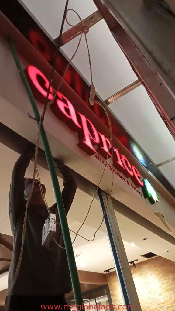 Acrylic signage installation for caprice on a commercial building in Mandaluyong by M&G Global Ads.