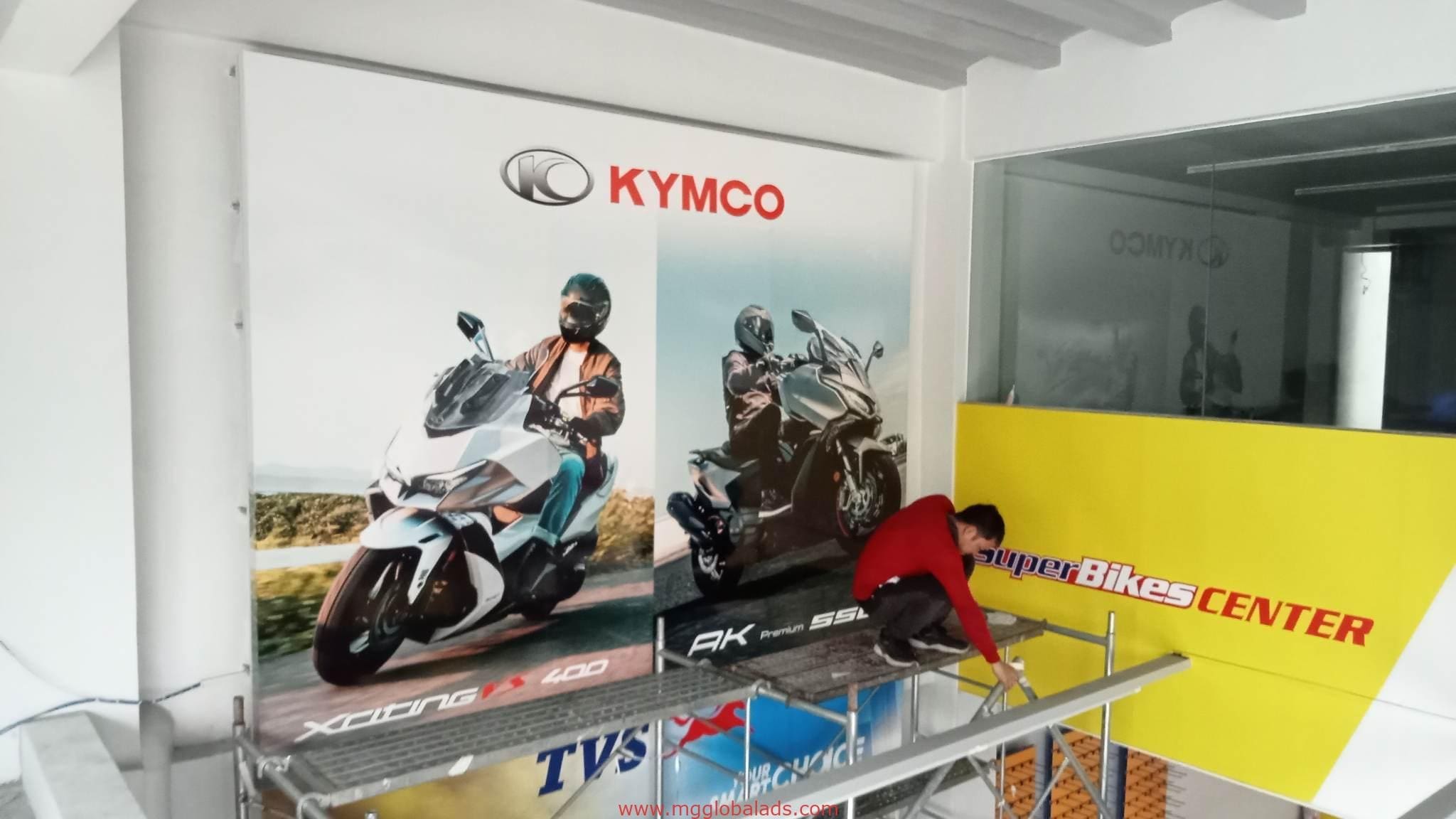SuperBikes CENTER building signage installation for KYMCO in Makati, featuring large scooter posters, by M&G Global Ads.