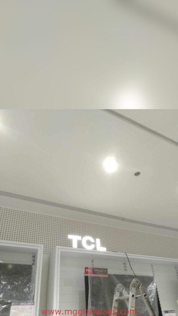 Illuminated TCL acrylic signage with recessed lighting and ladder in Quezon City showroom by M&G Global Ads.