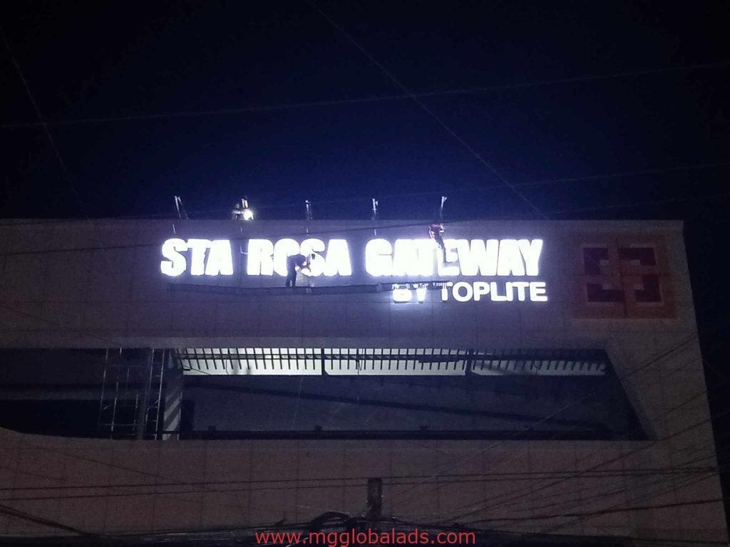 LED signage installation for STA ROSA GATEWAY by Toplite in Makati, workers use harnesses and ladders for safety by M&G Global Ads.
