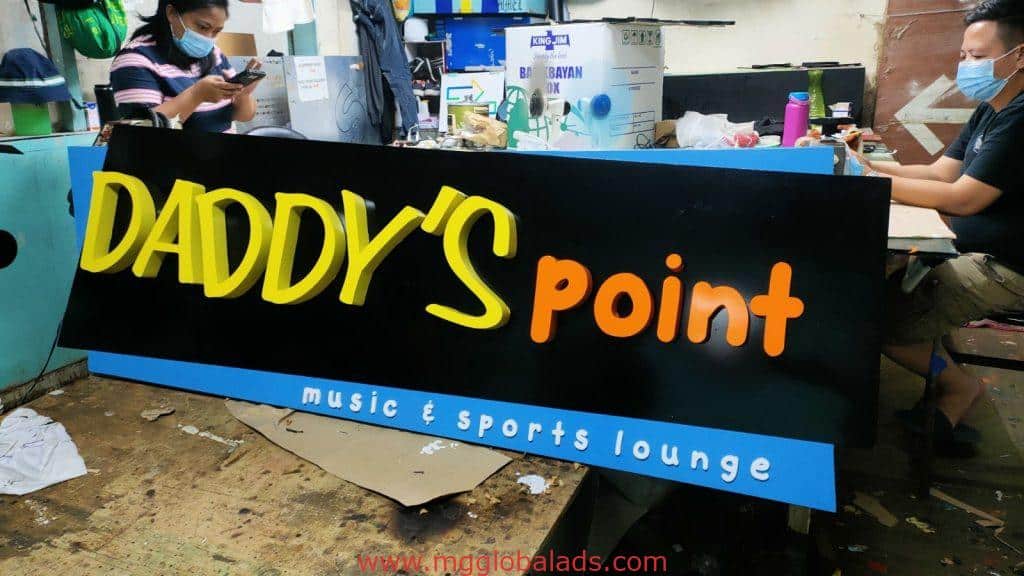 Outdoor bar signage for DADDYS point music & sports lounge in Makati, bold yellow-orange on black, by M&G Global Ads.