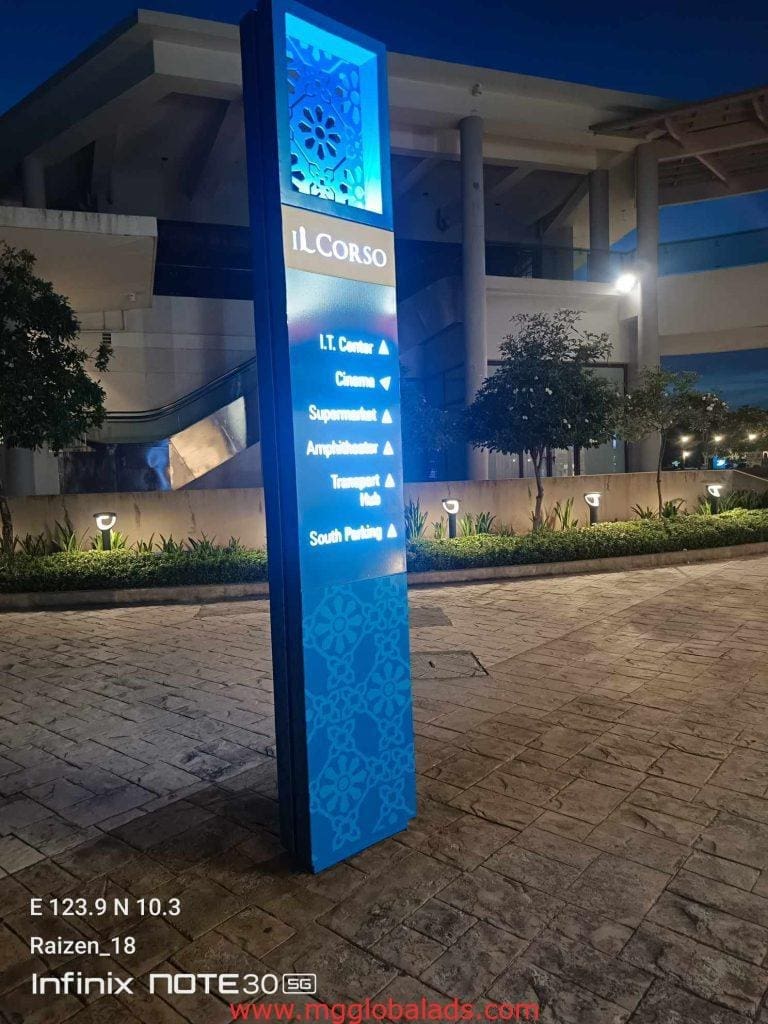 Illuminated blue LED directional signage for iL Corso in front of a modern building in BGC by M&G Global Ads.