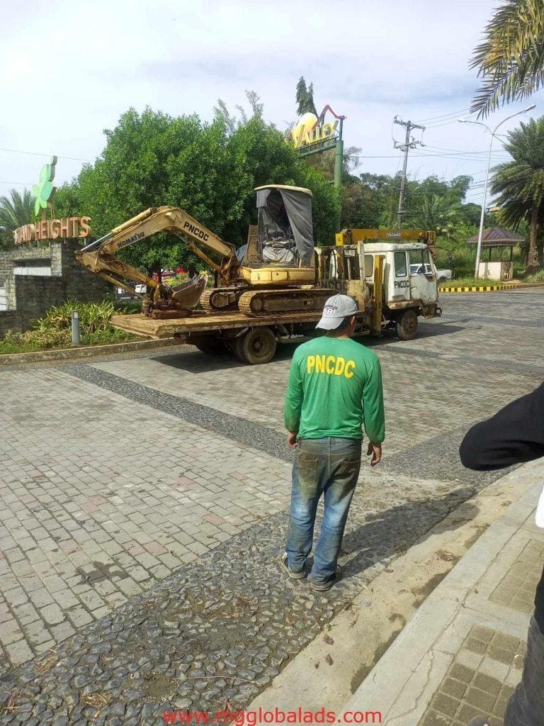 Outdoor building signage AH HEIGHTS for PNCDC client seen in Quezon City with truck and excavator by M&G Global Ads.