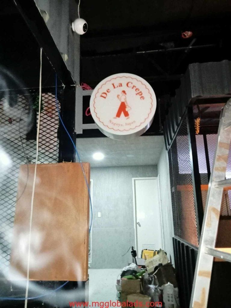Round LED shop signage for De La Crepe with chef logo in Makati, installation in progress by M&G Global Ads.