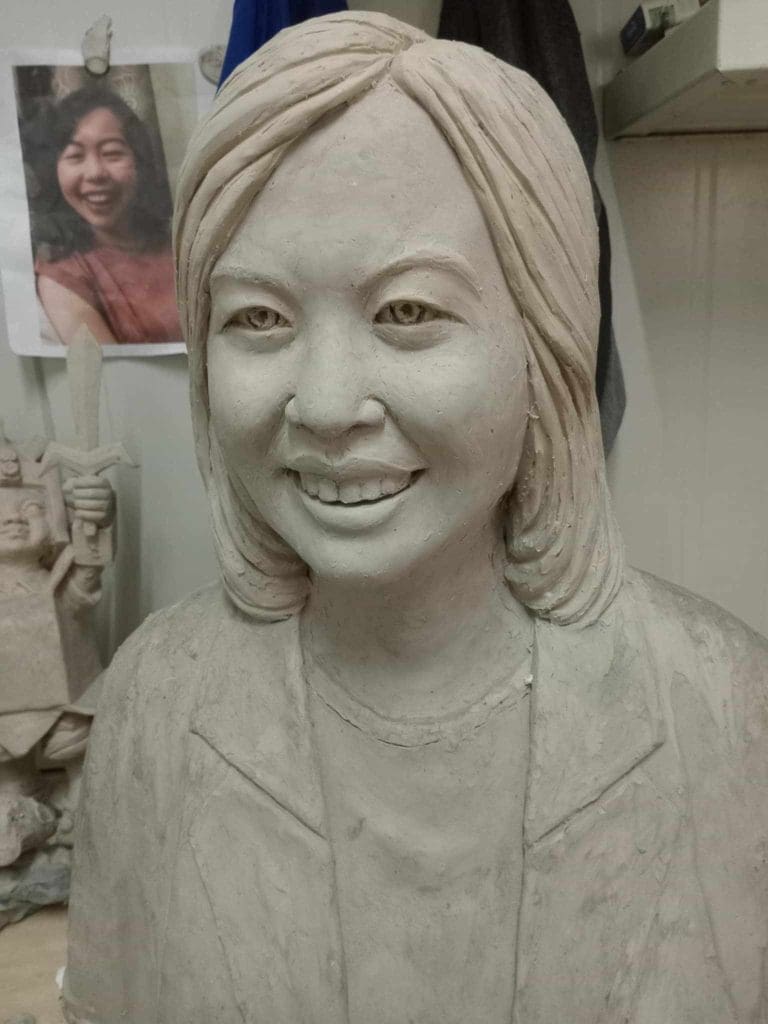 Clay bust and reference photo displayed in workshop with LED signage in Ortigas, creative space by M&G Global Ads.