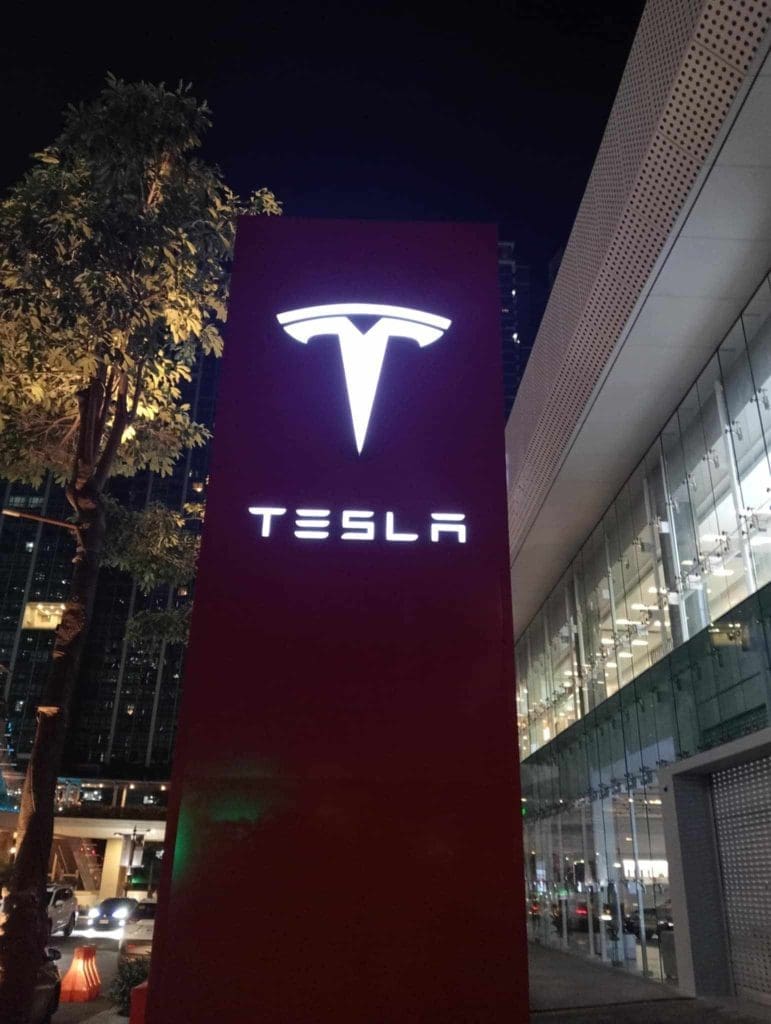 Tesla LED signage with illuminated logo outside glass building in Ortigas at night by M&G Global Ads.