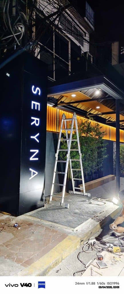 LED restaurant signage for SERYNA in Makati, shown at night with ladder and plants by entrance. By M&G Global Ads.
