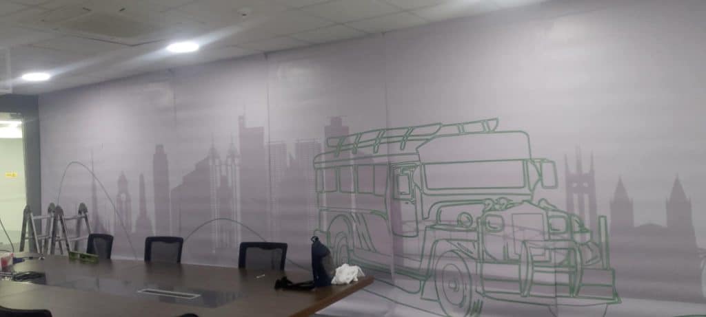 Acrylic signage in a modern conference room with jeepney mural, table and chairs in Makati by M&G Global Ads.