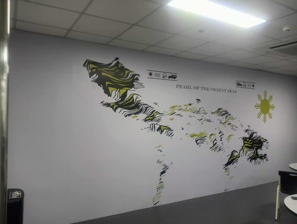 Metallic signage PEARL OF THE ORIENT SEAS mural in Makati with abstract patterns and sun by M&G Global Ads.