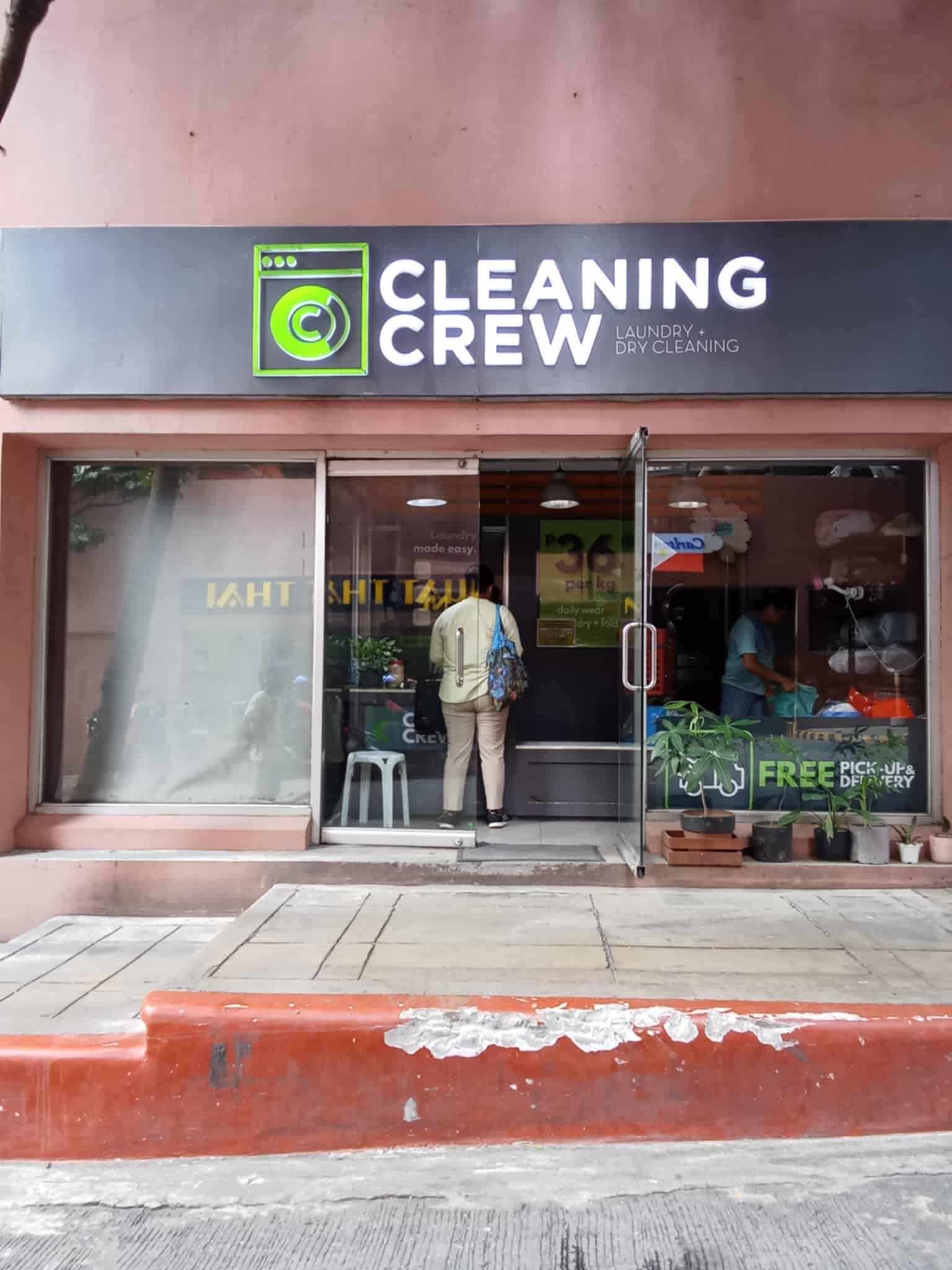 a store front with a sign and a person standing in front of it