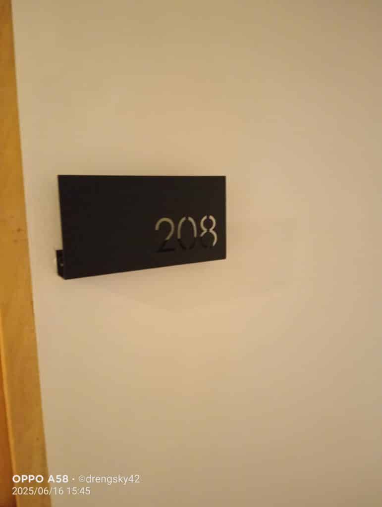Room number signage 208 in black metal on white wall, wooden door frame, Mandaluyong project by M&G Global Ads.