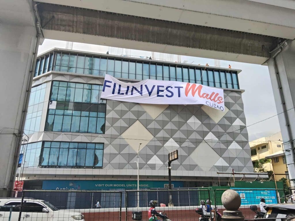 Large building banner signage for FILINVEST Malls at Cubao, Quezon City, with street view and rail, by M&G Global Ads.