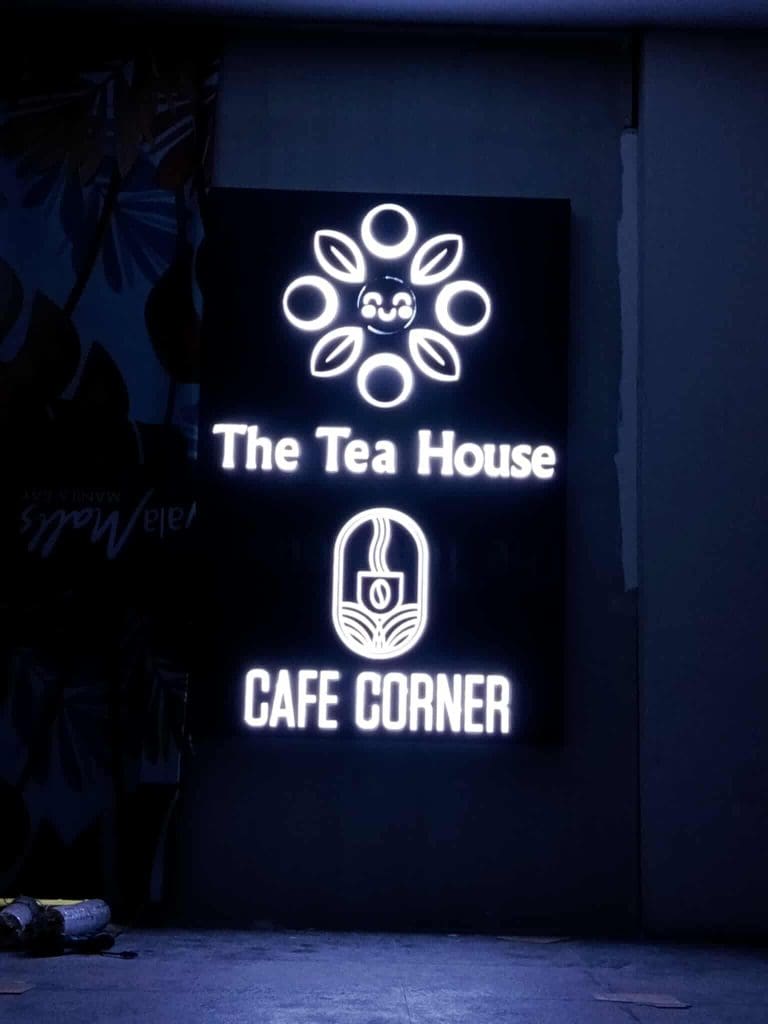 Neon signage for The Tea House Cafe Corner with logo and cup icon on dark wall in Ortigas, by M&G Global Ads.