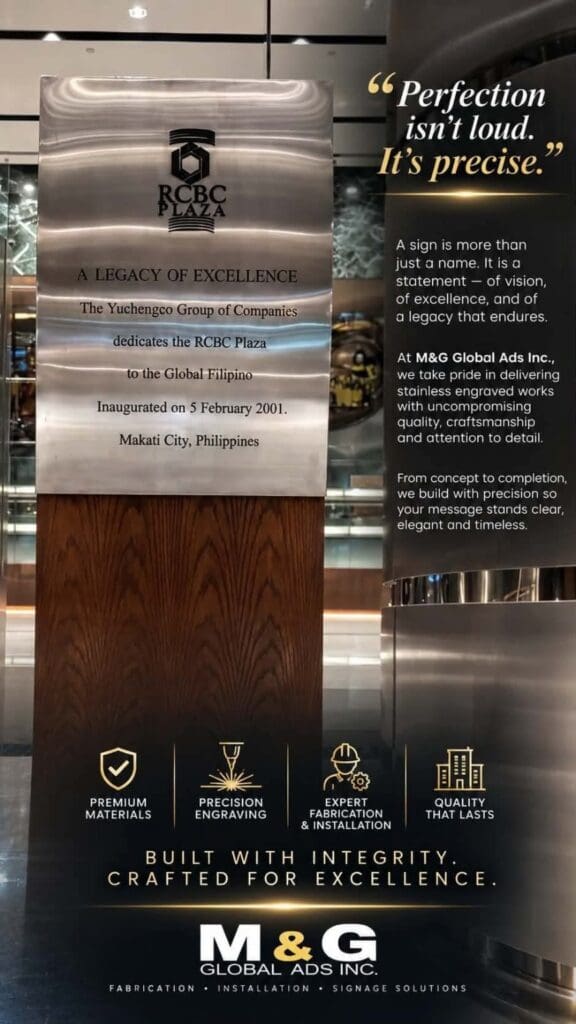 Stainless steel engraved plaque signage at RCBC Plaza, Makati, featuring dedication text and an adjacent sign with a precision quote and service details; high-quality custom metal sign by sign maker Philippines by M&G Global Ads.