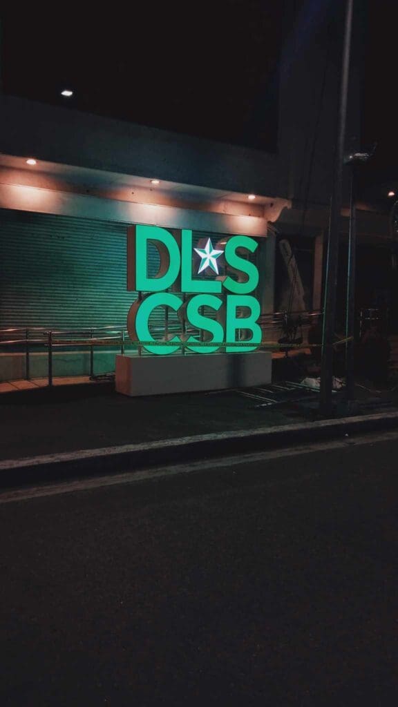 Outdoor LED acrylic building signage of green letters DLS CSB, Metro Manila, sign maker Philippines by M&G Global Ads.