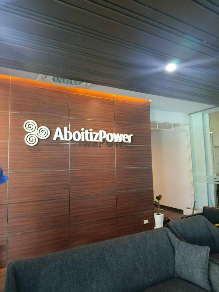 AboitizPower acrylic indoor signage on wooden wall, modern office lobby, Metro Manila, sign maker Philippines by M&G Global Ads.