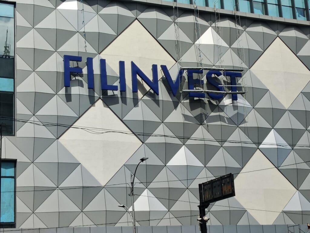 Acrylic building signage “FILINVEST” on modern facade in Metro Manila by sign maker Philippines, M&G Global Ads.