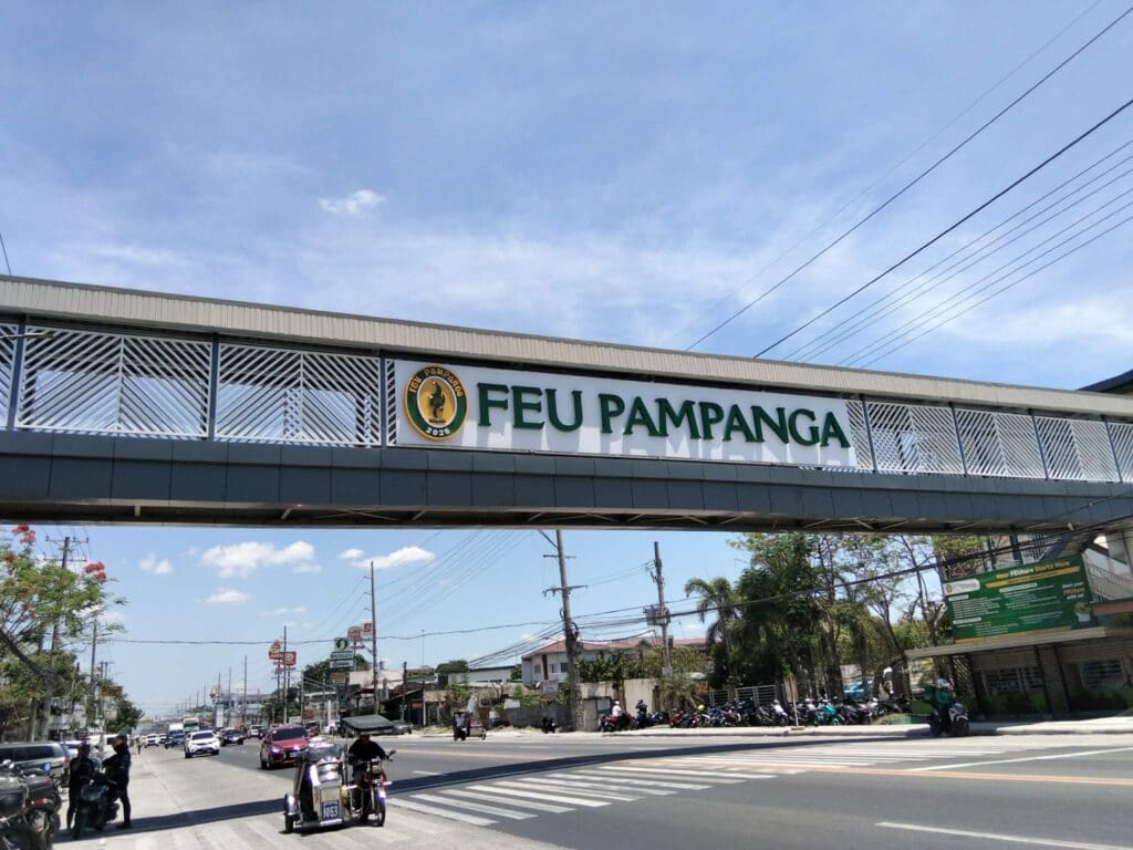 Acrylic building signage for FEU Pampanga on pedestrian overpass, busy road, Pampanga, sign maker Philippines by M&G Global Ads.