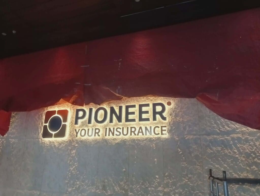 Acrylic illuminated wall signage for Pioneer Your Insurance on textured wall in Metro Manila, sign maker Philippines by M&G Global Ads.