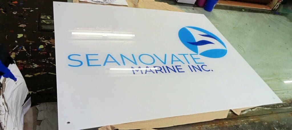 Acrylic indoor signage for SEANOVATE MARINE INC. with blue logo, in workshop, Metro Manila, sign maker Philippines by M&G Global Ads.
