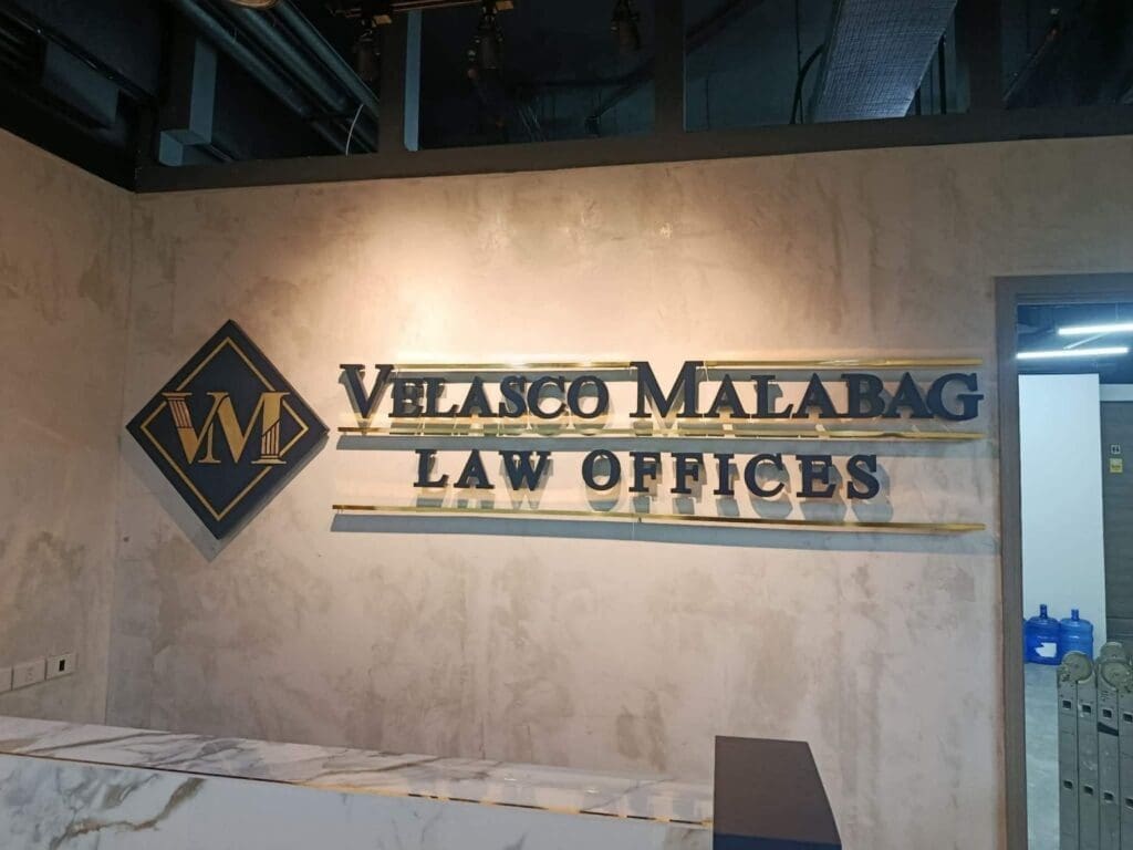 Acrylic indoor wall sign for Velasco Malabag Law Offices in marble-patterned office, Metro Manila. Sign maker Philippines by M&G Global Ads.