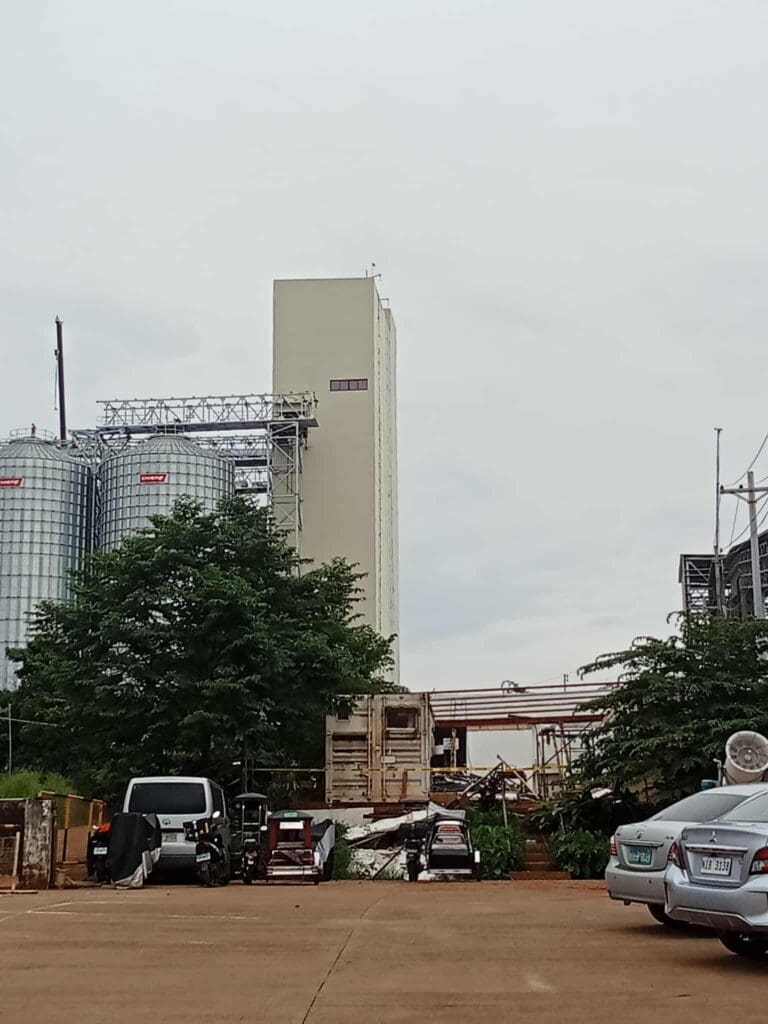 Industrial building with aluminum outdoor building signage, silos, trees, parking; sign maker Philippines by M&G Global Ads.