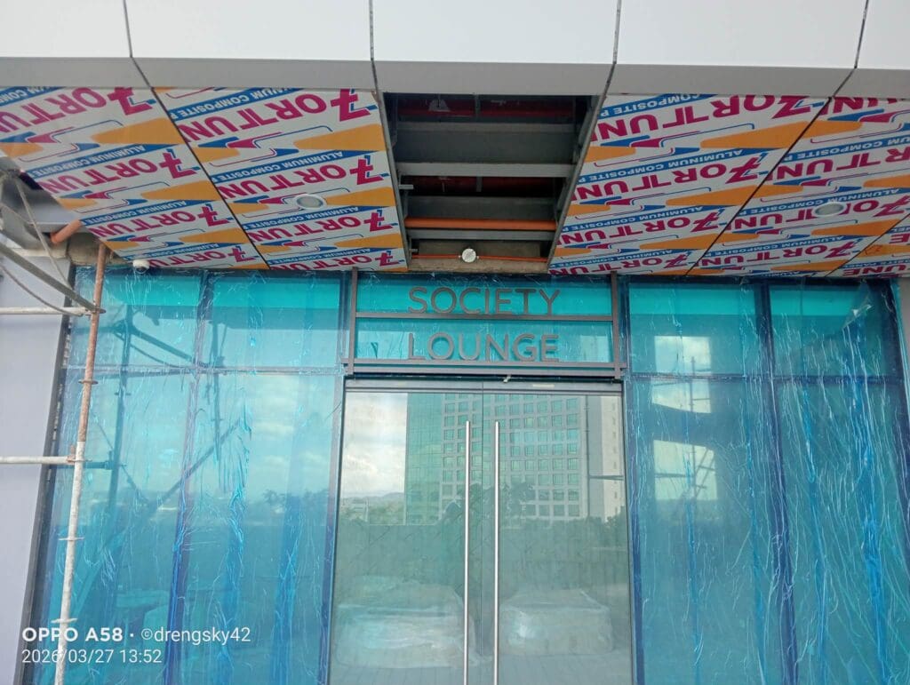 Building entrance in Metro Manila with blue glass doors and acrylic SOCIFETY LOUNGE signage, sign maker Philippines by M&G Global Ads.
