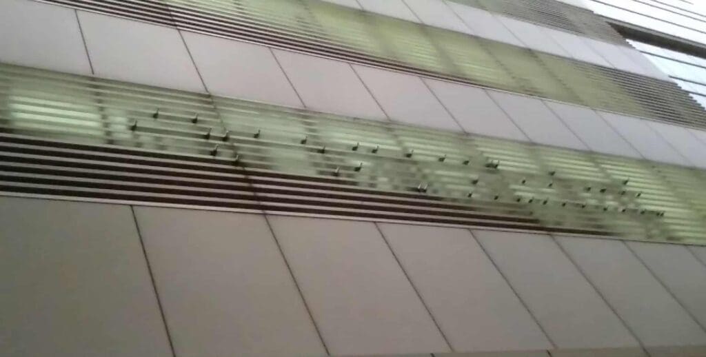 Building exterior with aluminum horizontal panels, narrow glass windows, outdoor signage; sign maker Philippines by M&G Global Ads.