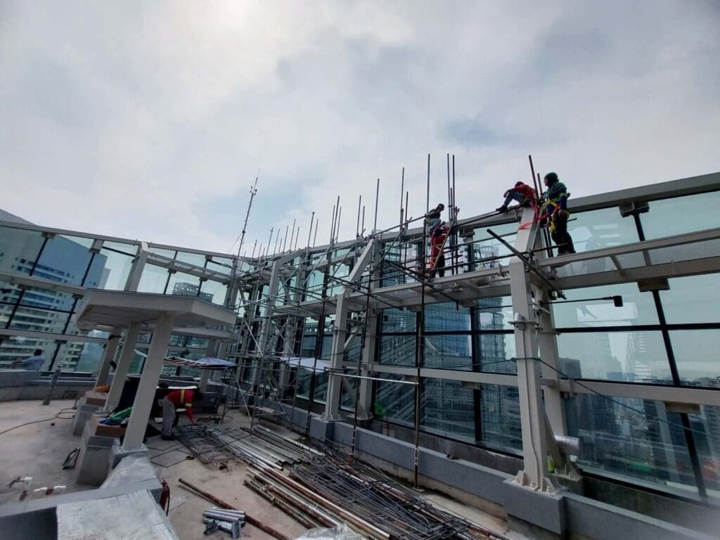 Building safety signage installation with metal beams and glass, high-rise Metro Manila, sign maker Philippines by M&G Global Ads.
