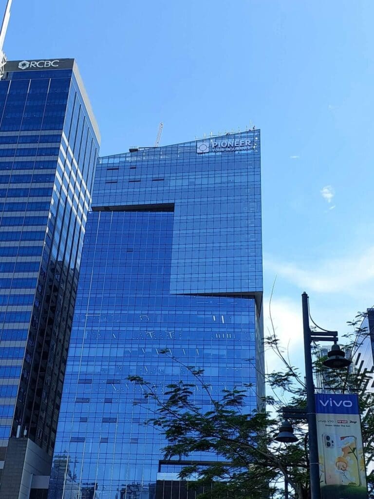 Building signage with RCBC and Pioneer acrylic/LED logos on tall glass offices, Metro Manila, sign maker Philippines by M&G Global Ads.