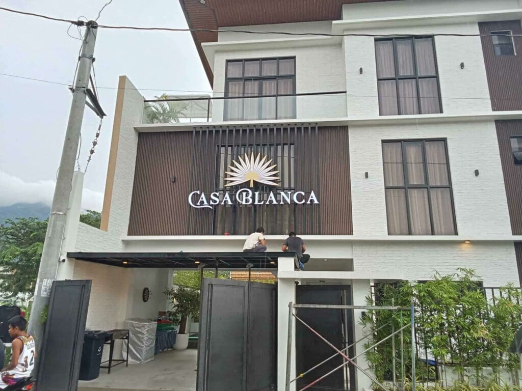 Casa Blanca acrylic building signage with sun logo, lush greenery, Metro Manila, sign maker Philippines by M&G Global Ads.