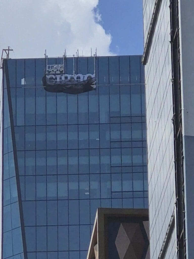 cigna outdoor building acrylic signage with some letters covered, on glass office in Philippines, sign maker Philippines by M&G Global Ads.
