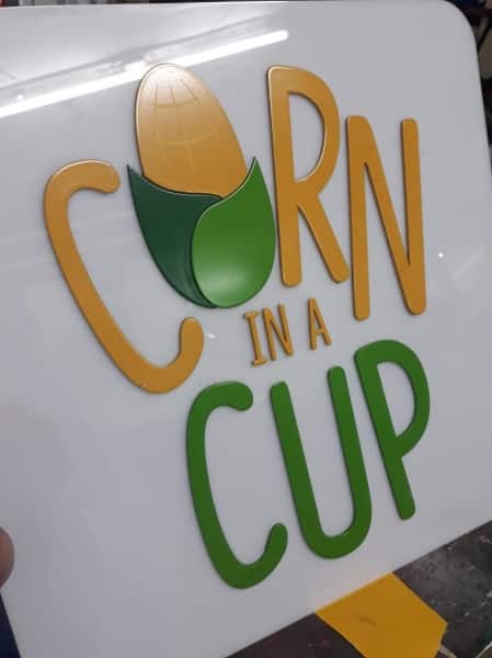 Acrylic signage for CORN IN A CUP with yellow and green text, corn graphic, Metro Manila sign maker Philippines by M&G Global Ads.