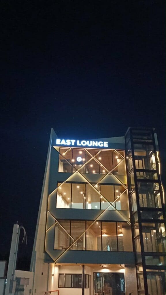EAST LOUNGE LED building signage in bright white letters on a modern glass building at night, Metro Manila. Sign maker Philippines by M&G Global Ads.