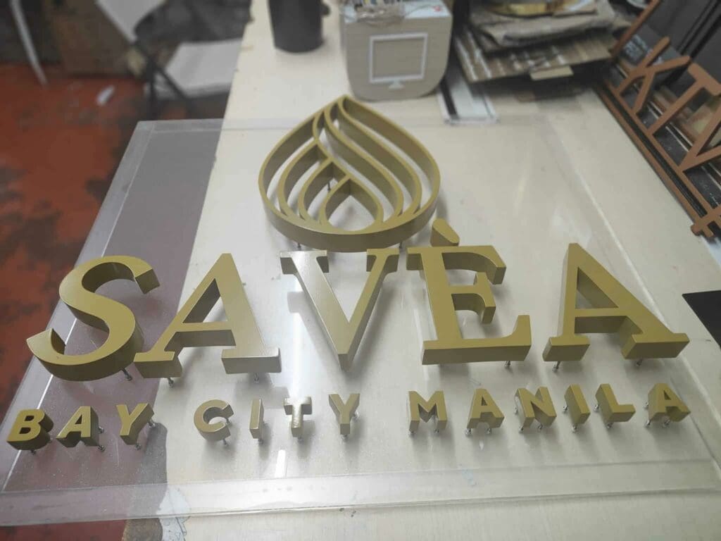 Gold 3D brass letters acrylic signage SAVÉA BAY CITY MANILA, workshop view, Metro Manila, sign maker Philippines by M&G Global Ads.