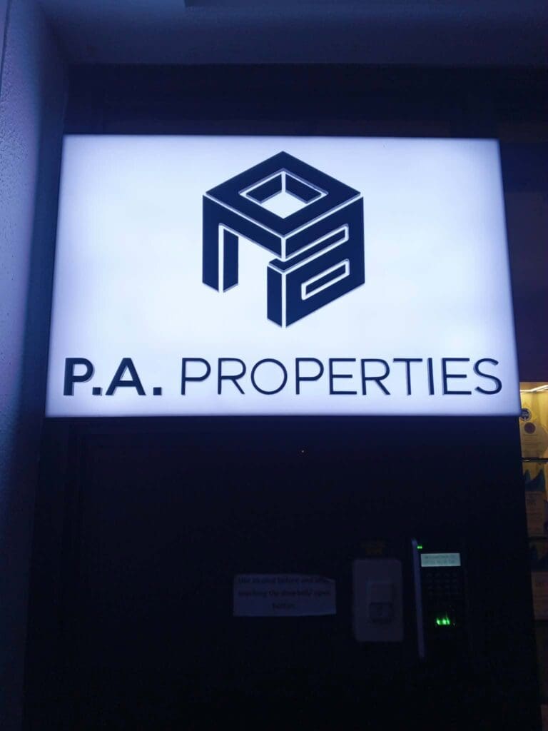 Illuminated acrylic building signage for P.A. PROPERTIES, featuring black text and a geometric black logo above it, mounted on a dark wall in Metro Manila, sign maker Philippines by M&G Global Ads.